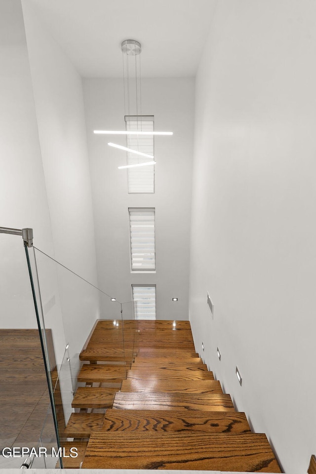 stairway featuring dark hardwood / wood-style flooring and a notable chandelier