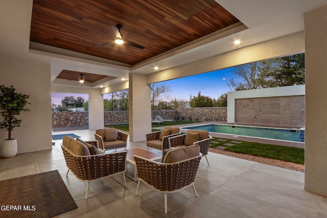 patio terrace at dusk featuring an outdoor living space, ceiling fan, and a fenced in pool