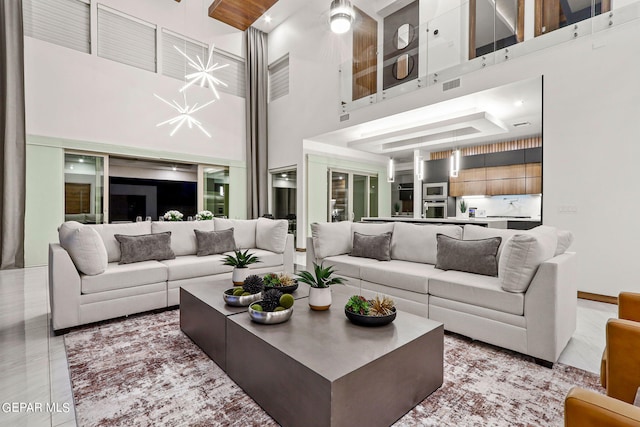 tiled living room with a notable chandelier and a high ceiling