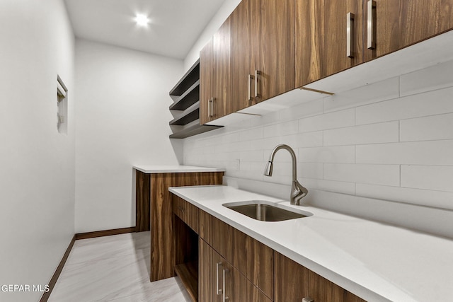 kitchen featuring light tile flooring, tasteful backsplash, and sink