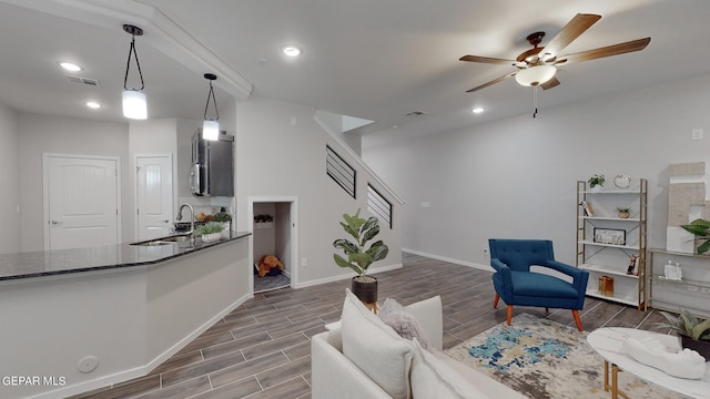 living room featuring dark hardwood / wood-style flooring, ceiling fan, and sink