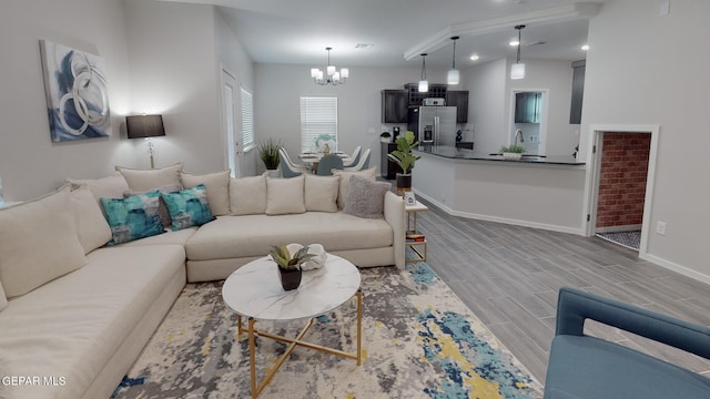 living room with lofted ceiling, light hardwood / wood-style flooring, and a chandelier