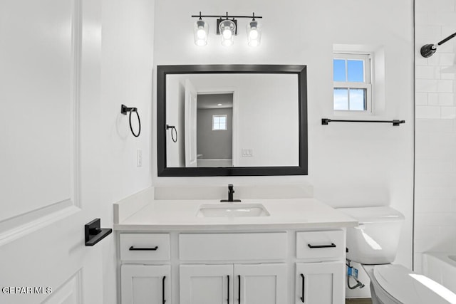 full bathroom with toilet, vanity, and tiled shower / bath