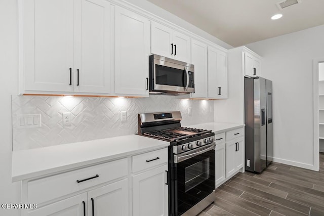 kitchen featuring backsplash, white cabinetry, dark hardwood / wood-style floors, and appliances with stainless steel finishes