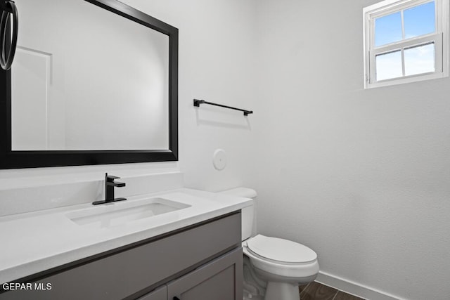 bathroom featuring wood-type flooring, toilet, and vanity