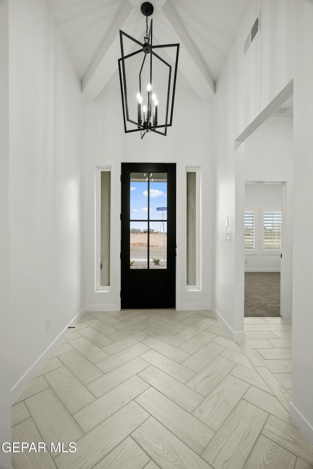 foyer entrance featuring high vaulted ceiling, visible vents, and baseboards