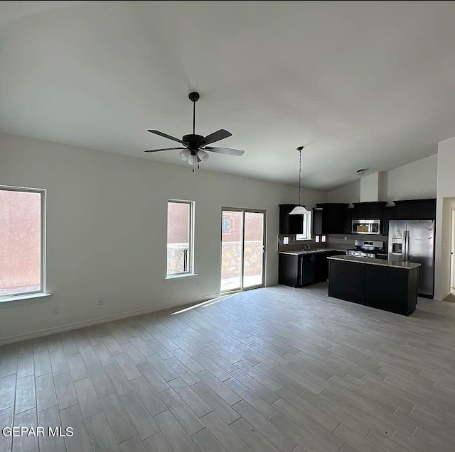 interior space with light hardwood / wood-style flooring, a center island, ceiling fan, and appliances with stainless steel finishes