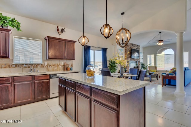 kitchen featuring hanging light fixtures, dishwasher, tasteful backsplash, ceiling fan with notable chandelier, and a center island