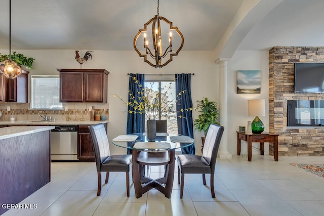 dining space featuring a healthy amount of sunlight, light tile floors, sink, and an inviting chandelier