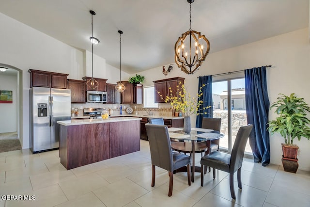 kitchen featuring light tile flooring, plenty of natural light, pendant lighting, and appliances with stainless steel finishes