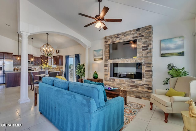 tiled living room featuring decorative columns, ceiling fan with notable chandelier, and lofted ceiling