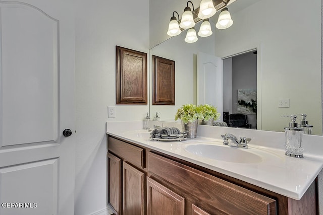 bathroom with an inviting chandelier, double sink, and vanity with extensive cabinet space