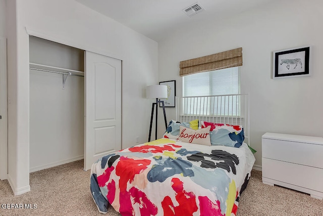 bedroom with a closet and light colored carpet