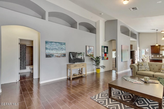 living room with high vaulted ceiling and dark wood-type flooring