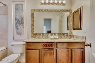 bathroom featuring double sink, large vanity, and toilet