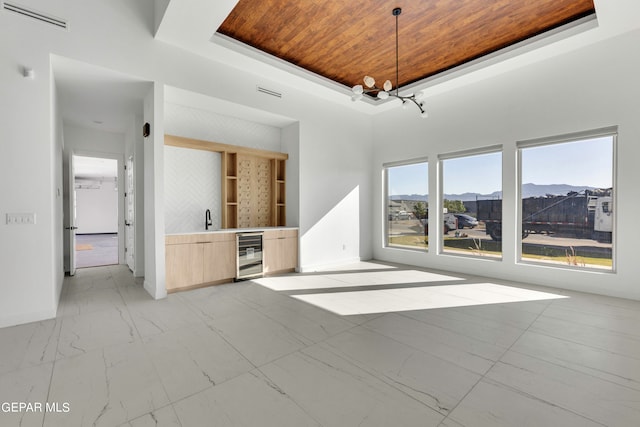 469 Country Oaks Dr, El Paso, TX 79932 - unfurnished living room with a mountain view, wine cooler, sink, a chandelier, and wooden ceiling