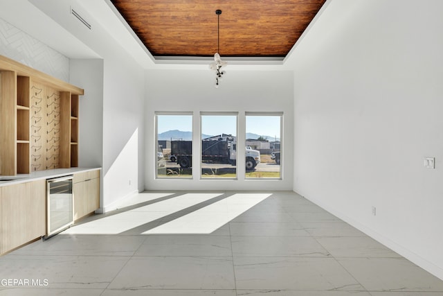 469 Country Oaks Dr, El Paso, TX 79932 - unfurnished living room featuring wine cooler, wood ceiling, and a tray ceiling