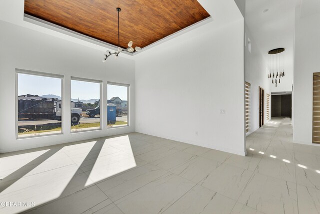 469 Country Oaks Dr, El Paso, TX 79932 - unfurnished living room with a towering ceiling, a notable chandelier, and wooden ceiling