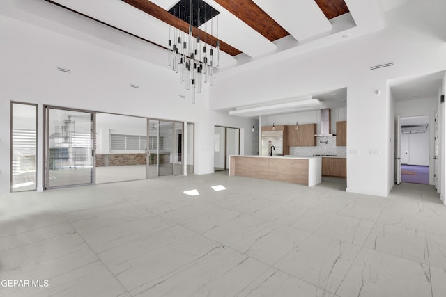 469 Country Oaks Dr, El Paso, TX 79932 - unfurnished living room featuring a towering ceiling, beamed ceiling, and sink