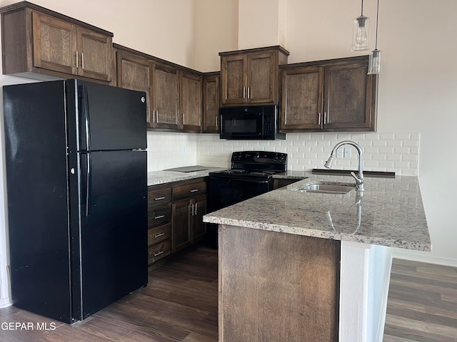 kitchen featuring dark wood-type flooring, tasteful backsplash, sink, black appliances, and hanging light fixtures