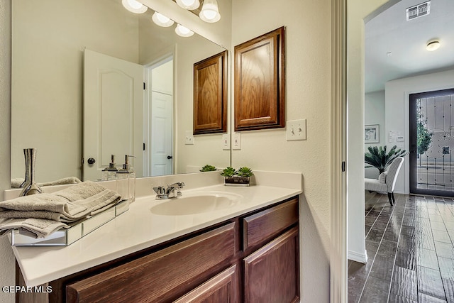 bathroom featuring vanity with extensive cabinet space and hardwood / wood-style flooring