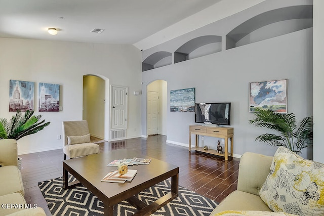 living room with high vaulted ceiling and dark wood-type flooring