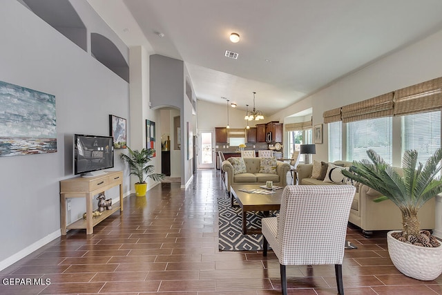 living room with a notable chandelier and high vaulted ceiling