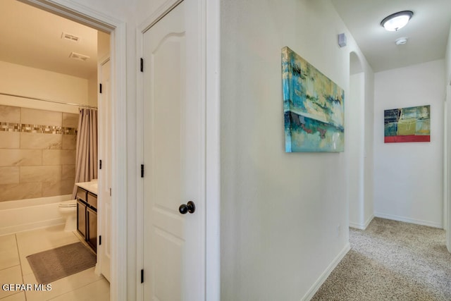 hallway featuring light colored carpet