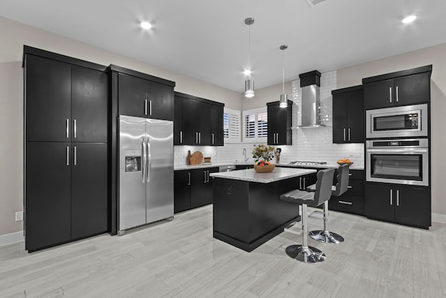 kitchen featuring backsplash, stainless steel appliances, a center island, wall chimney exhaust hood, and pendant lighting