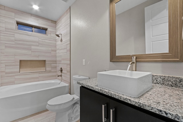 full bathroom with toilet, tiled shower / bath combo, and vanity