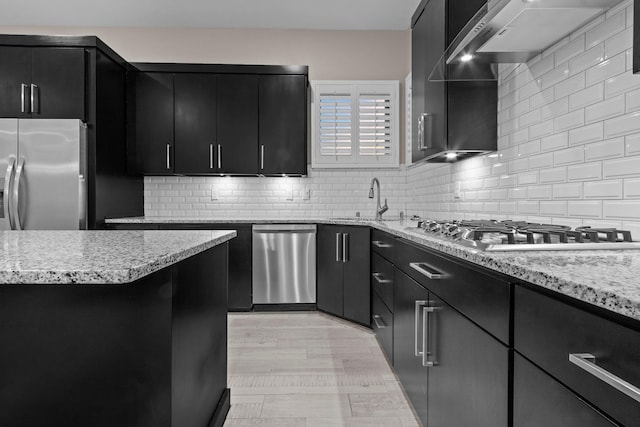 kitchen featuring tasteful backsplash, light stone counters, and stainless steel appliances