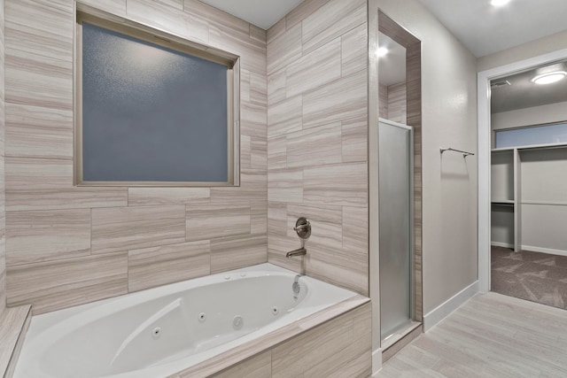 bathroom featuring tile walls and separate shower and tub