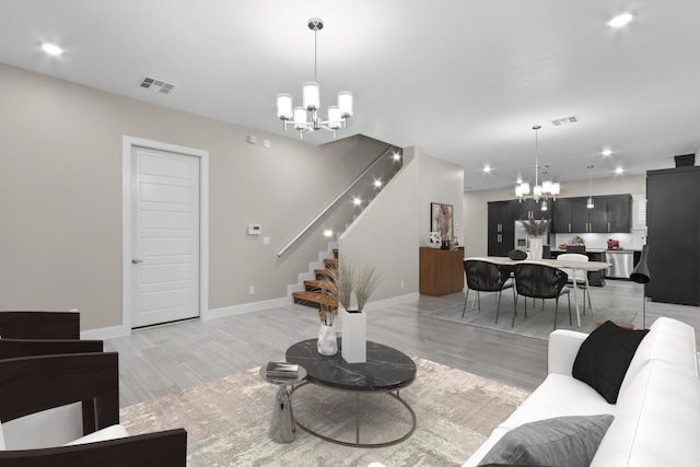 living room featuring an inviting chandelier and light hardwood / wood-style flooring