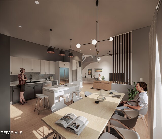 dining space featuring an inviting chandelier, sink, and light hardwood / wood-style floors