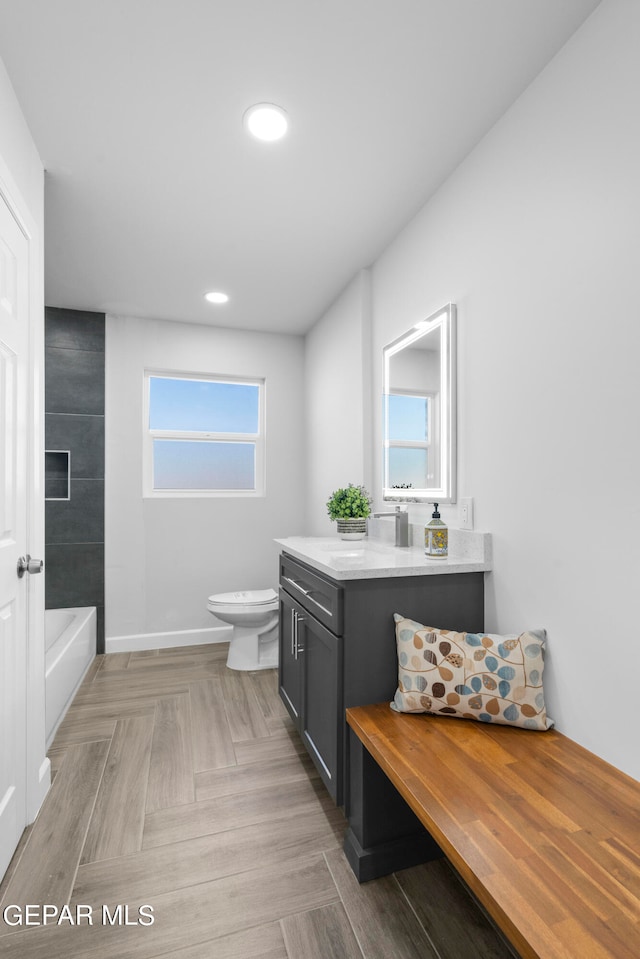 full bathroom with toilet, vanity, parquet floors, and tiled shower / bath