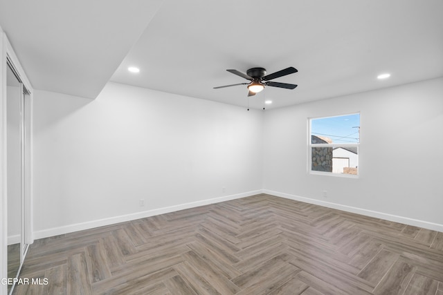 empty room featuring dark parquet flooring and ceiling fan