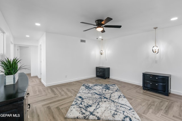 living area with ceiling fan and light parquet flooring