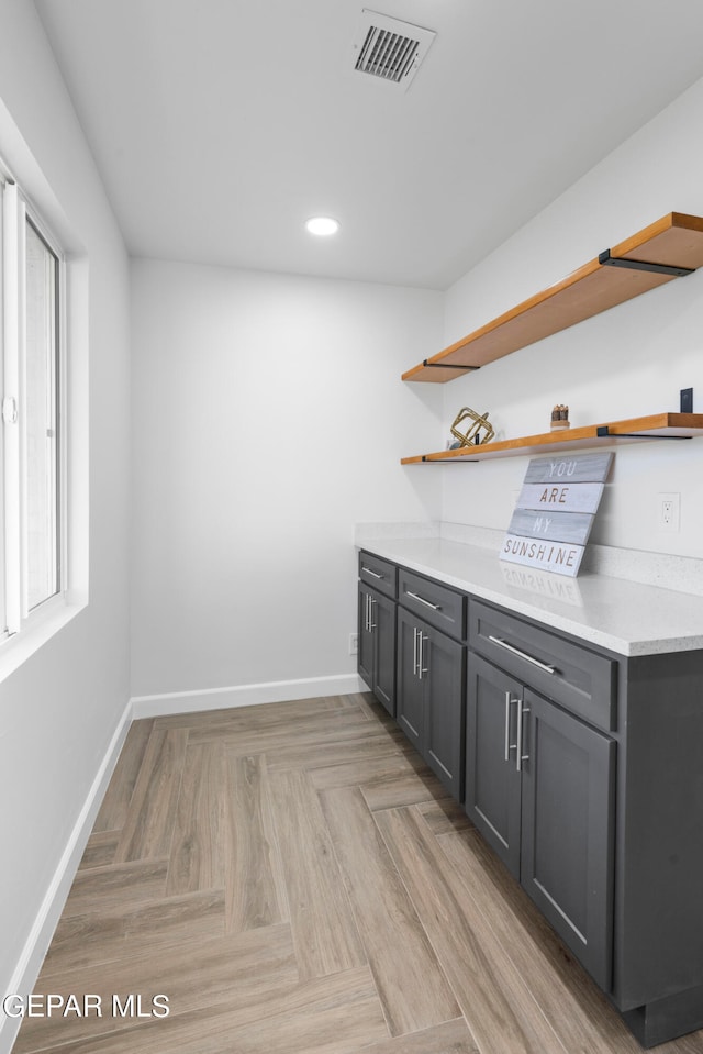 interior space with gray cabinetry and light parquet flooring