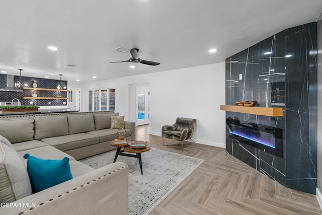 living room featuring light parquet floors and ceiling fan with notable chandelier