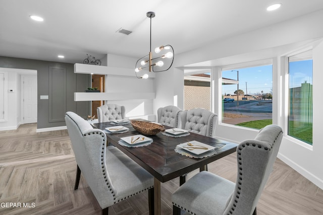 dining room with an inviting chandelier and light parquet flooring