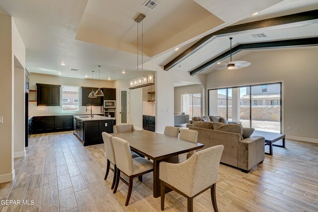 dining space featuring visible vents, vaulted ceiling with beams, baseboards, ceiling fan, and wood finish floors