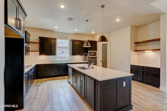 kitchen featuring visible vents, a sink, appliances with stainless steel finishes, light wood-style floors, and open shelves