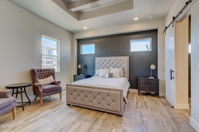 bedroom with light wood-type flooring, a barn door, baseboards, and recessed lighting