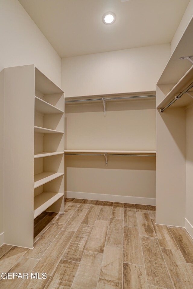 walk in closet featuring wood finish floors