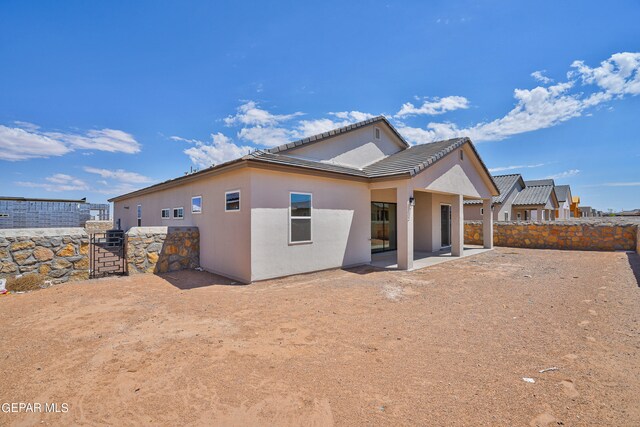 back of house featuring a patio area, stucco siding, a tiled roof, and fence