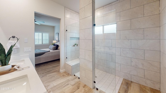 bathroom with ceiling fan, vanity, and a tile shower