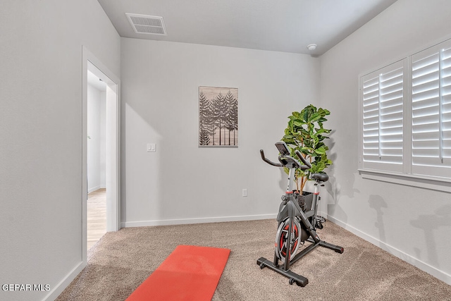 exercise area featuring carpet flooring, visible vents, and baseboards