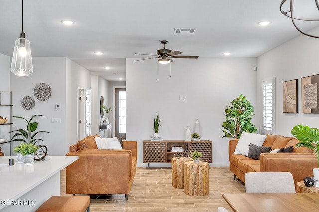 living area featuring recessed lighting, visible vents, light wood-style floors, a ceiling fan, and baseboards