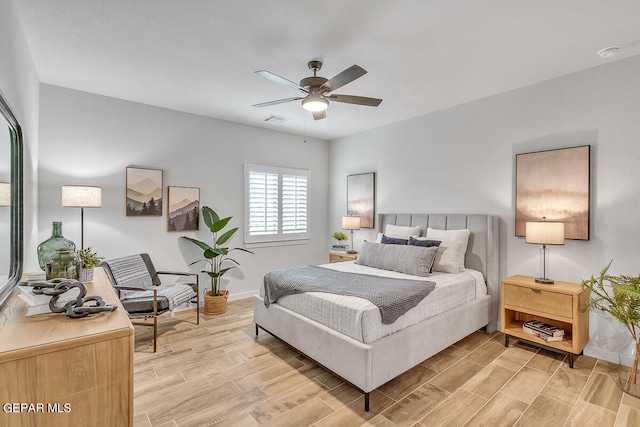 bedroom with baseboards, wood tiled floor, visible vents, and a ceiling fan