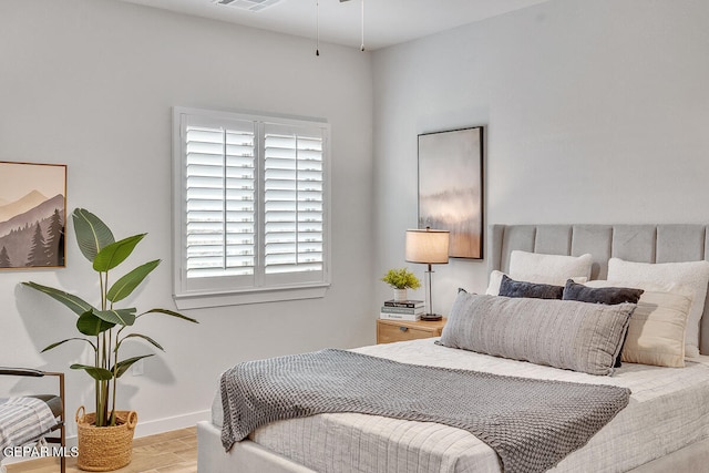 bedroom featuring light wood-type flooring, visible vents, and baseboards